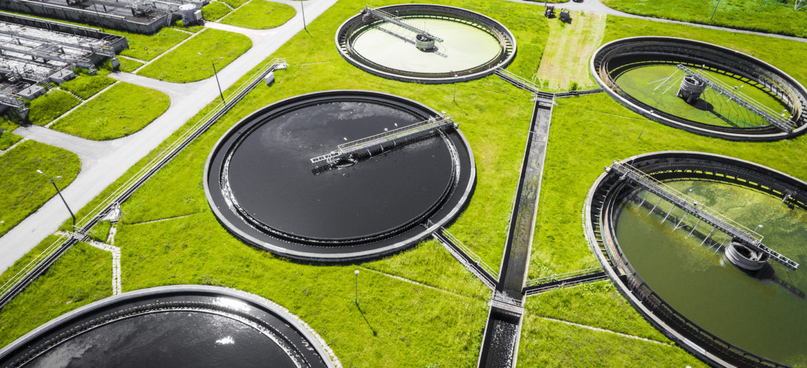 Sewage farm. Static aerial photo looking down onto the clarifying tanks and green grass. Geometric background texture.